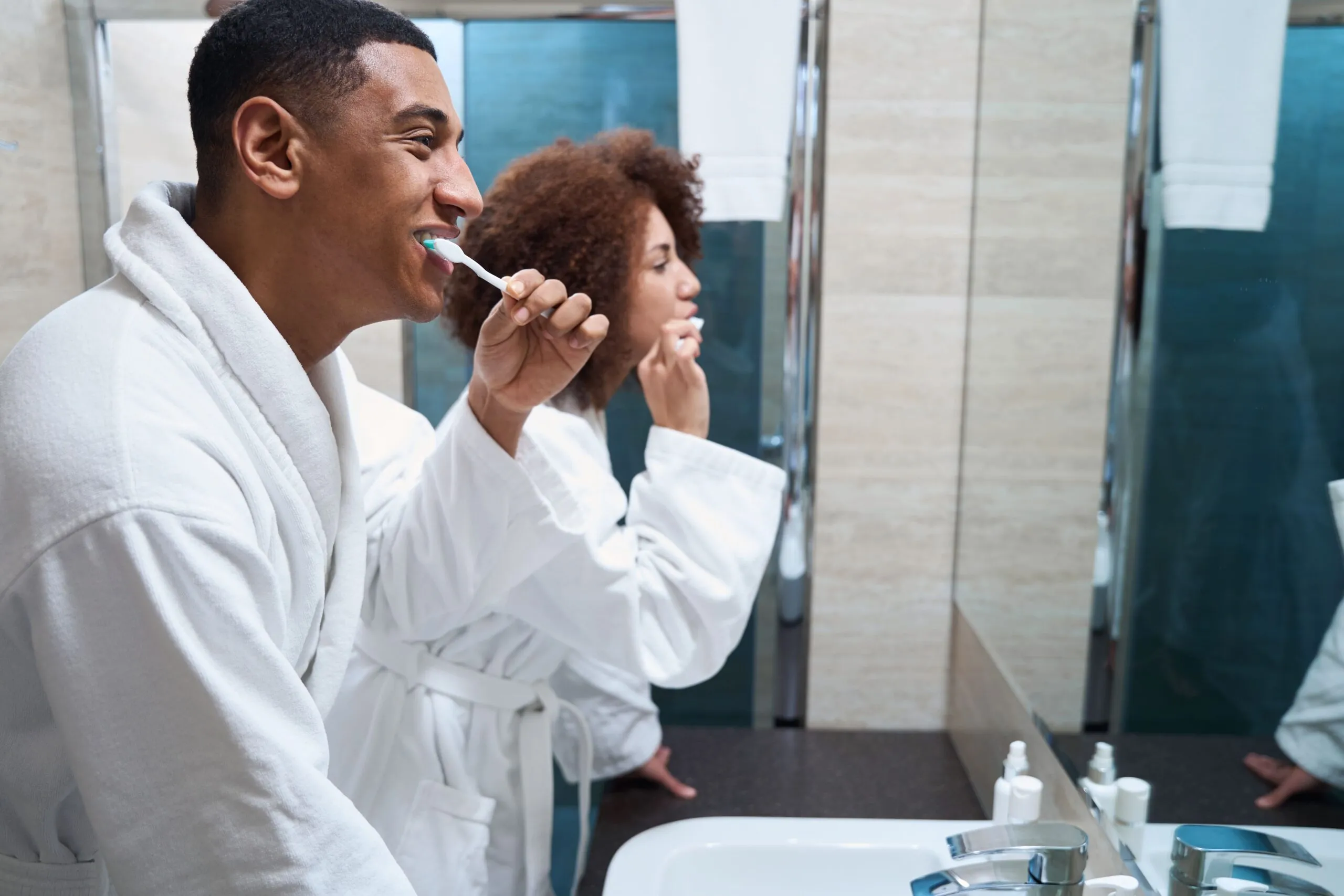 man and a woman brush teeth
